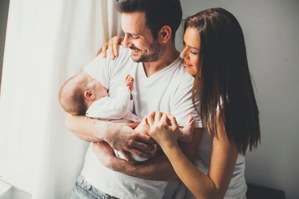 Happy adoptive family holding their newly adopted baby