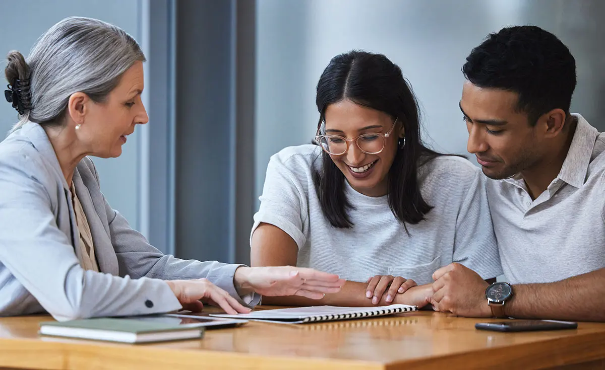 Prospective adoptive parents meeting with an adoption specialist to review adoption costs and fees