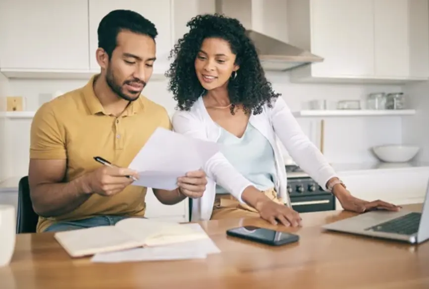 Prospective adoptive couple preparing home study paperwork for their adoption journey