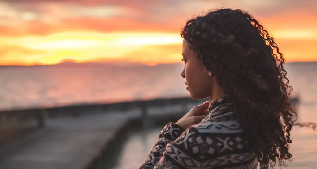 Expectant mother looking toward the horizon while exploring her adoption options with Heart to Heart Adoptions.